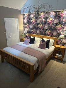 ein Schlafzimmer mit einem großen Bett mit Blumenwand in der Unterkunft Wild Atlantic Lodge Bed & Breakfast in Lahinch