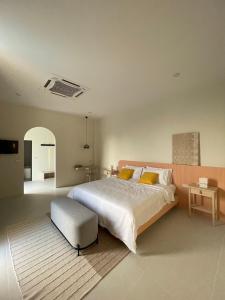 Karisma Private Villa Pattaya في جومتين بيتش: غرفة نوم مع سرير كبير والعثمانية