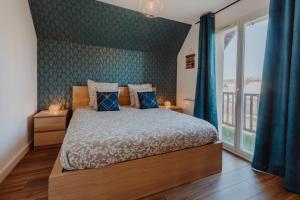 a bedroom with a bed and a large window at Appartement 2 chambres aux portes de Deauville 100m du Pôle International du cheval in Saint-Arnoult