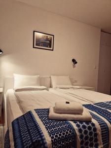 a hotel room with two beds with towels on them at Pansion Hukić B&B in Tuzla
