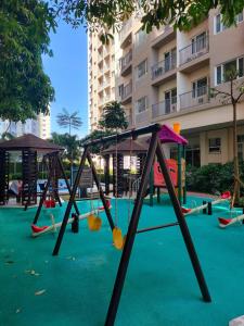 a playground in front of a building with swings at South residence in Manila