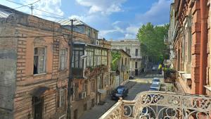 een balkon met uitzicht op een straat met gebouwen bij Home away from home in Tbilisi City