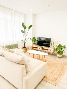 sala de estar con sofá blanco y mesa en A Lobeira Grande by ALÔGA, en Cee