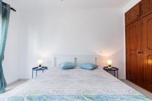 - une chambre avec un grand lit et des oreillers bleus dans l'établissement Apartamento MANTAMAR by ALGARVEMANTA, à Manta Rota