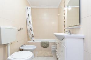 Un baño blanco con inodoro y lavabo. en Apartamento MANTAMAR by ALGARVEMANTA, en Manta Rota 14 fotos más