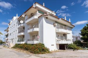Un edificio blanco con balcones a los lados. en Apartamento MANTAMAR by ALGARVEMANTA, en Manta Rota