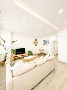 a white living room with a couch and a table at A Lobeira Grande by ALÔGA in Cee