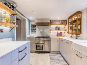 una cucina con armadietti bianchi e piano cottura di Pass the Keys Beautiful Cottage In South Downs a Chichester