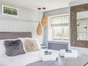 una camera da letto con un letto bianco e asciugamani di Pass the Keys Beautiful Cottage In South Downs a Chichester