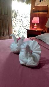 a white towel animal is sitting on a bed at Sun Creek Lodge in Punta Gorda