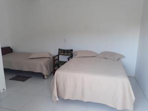 - une chambre blanche avec un lit et un canapé dans l'établissement Recanto da Preguiça - Suites, à Pontal do Paraná