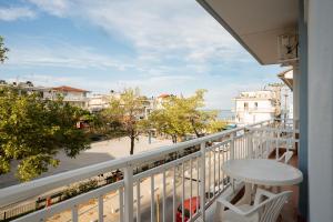 a balcony with a table and a view of a street at Villa Estelle in Paralia Katerinis