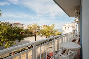 a balcony with a table and a view of a street at Villa Estelle in Paralia Katerinis