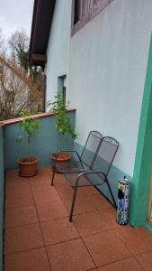 a chair sitting on a patio with two potted plants at FreiNestWaldviertel in Hoheneich
