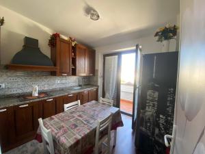 a kitchen with a table with chairs and a window at I 4 mori in Fiumicino +9 photos