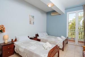 a bedroom with two beds and a window at Villa Estelle in Paralia Katerinis