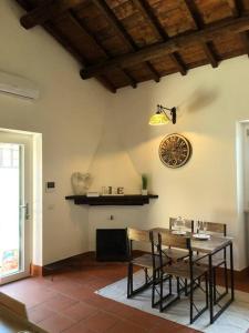 a dining room with a table and a clock on the wall at Delizioso Loft nel Casale con giardino in Olgiata