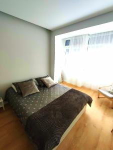 łóżko w sypialni z dużym oknem w obiekcie Elite House Estoril w mieście Estoril