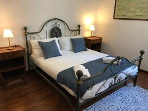 a bedroom with a large bed with blue and white pillows at Delizioso Loft nel Casale con giardino in Olgiata