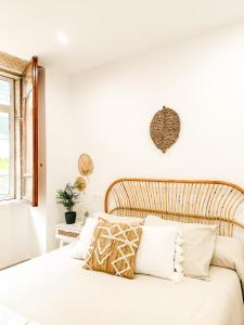 1 dormitorio con cama blanca y cabecero de madera en A Lobeira Grande by ALÔGA, en Cee