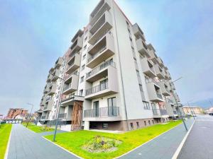 a large apartment building with a green lawn in front of it at Transalpina Residence 17 in Alba Iulia