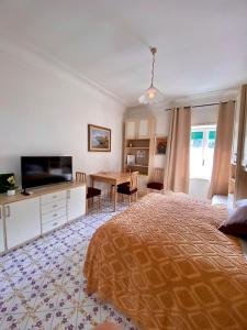 1 dormitorio con 1 cama y 1 mesa con TV en Central Studio Capri, en Capri