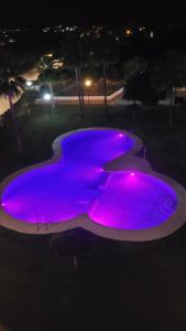 einen Pool mit lila Lichtern in der Nacht in der Unterkunft Casa Trebol Parquing Gratis in Estepona