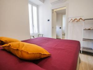 - une chambre avec un grand lit et des oreillers jaunes dans l'établissement Casa Anselmo, à Côme