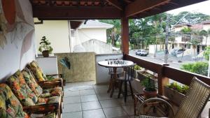 eine Terrasse mit Stühlen und einem Tisch auf dem Balkon in der Unterkunft Pousada Primavera in Caraguatatuba