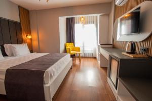 Habitación de hotel con cama y TV en Rodis Hotel, en Izmir