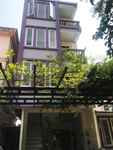 a purple building with plants in front of it at Nary Apartment in Siem Reap