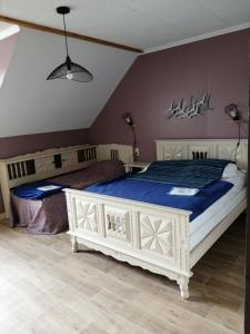 a bedroom with a white bed with a blue comforter at Gîte Hydrangea in Lanhélin