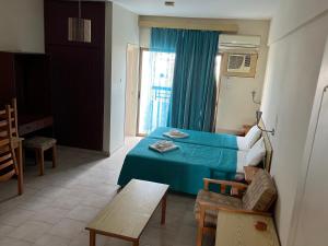 Habitación con cama, mesa y ventana en Maouris Hotel Apartments, en Protaras
