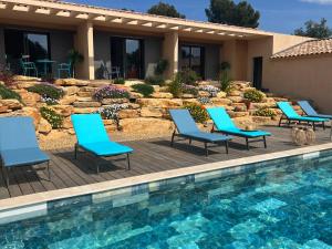 eine Terrasse mit Stühlen und einem Pool in der Unterkunft L' Inattendu in Laouque