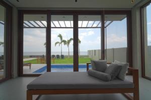 a room with a bed with a view of the ocean at Araya Beach Casas in Batangas City