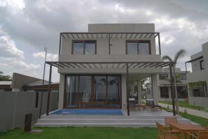 a house with a pool in front of it at Araya Beach Casas in Batangas City