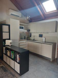 une cuisine avec des placards blancs et un comptoir noir dans l'établissement La Buschera, à Bra