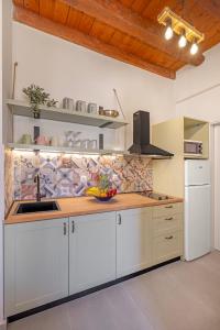eine Küche mit weißen Schränken und einer hölzernen Arbeitsplatte in der Unterkunft Casa Della vita Loft ,Rhodes Old town in Rhodos (Stadt)
