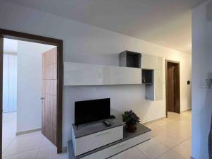 a living room with a flat screen tv on a wall at Lovely 3 Bedroom Condo in St. Julianʼs