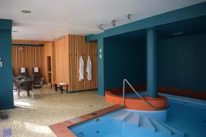 een zwembad in een kamer met een tafel en stoelen bij Amber Sea Hotel & SPA in Jūrmala