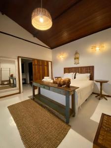 um quarto com uma cama com uma mesa em Pousada Casa da Praia em Caraíva