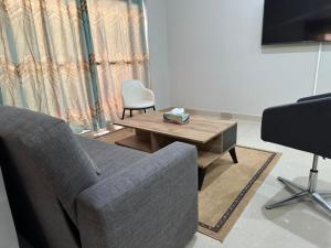 ein Wohnzimmer mit einem Sofa und einem Tisch in der Unterkunft Janneya Apartments in Sukuta
