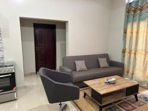 ein Wohnzimmer mit einem Sofa und einem Couchtisch in der Unterkunft Janneya Apartments in Sukuta