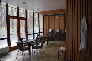 un grupo de mesas y sillas en una habitación con ventanas en Amber Sea Hotel & SPA en Jūrmala