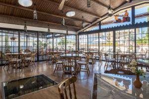 a dining room with tables and chairs and windows at Anais Bay Hotel in Protaras