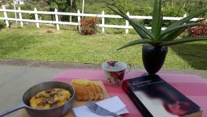 a table with a plate of food and a book at Hermosa cabaña amoblada en Pueblo Bello, Sierra Nevada in Pueblo Bello