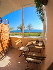 a table and chairs in a room with a large window at Sunset Yavorov Pomorie in Pomorie