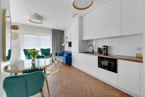 a kitchen and living room with a glass table and chairs at Blue Lagoon przy Motławie in Gdańsk