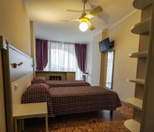 een slaapkamer met 2 bedden en een plafondventilator bij Hotel Bellavista in San Bartolomeo al Mare