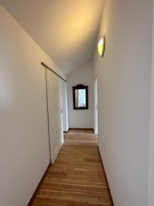 un couloir vide avec une porte et un miroir dans l'établissement Matisse Residence, à Nerezine